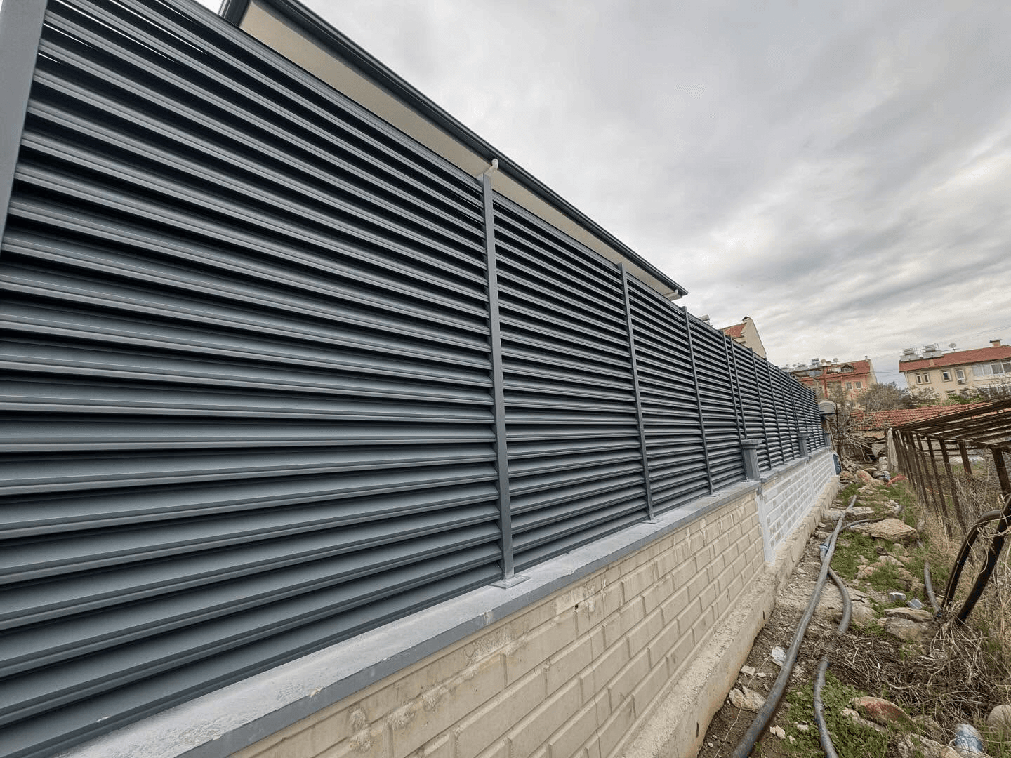 Aluminum louver fence on retaining wall